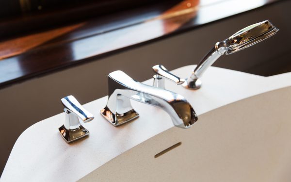 sanitary, plumbing and washing concept - close up of bath tap and shower at bathroom